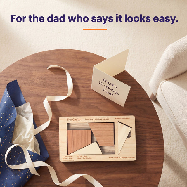 The Cruiser puzzle on a side table beside navy wrapping and a Happy Birthday Dad card, with the headline For the dad who says it looks easy.