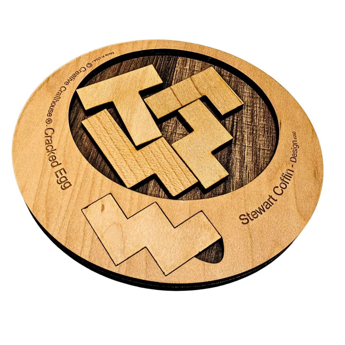 Cracked Egg wooden dissection puzzle with loose shaped pieces in and beside an oval frame