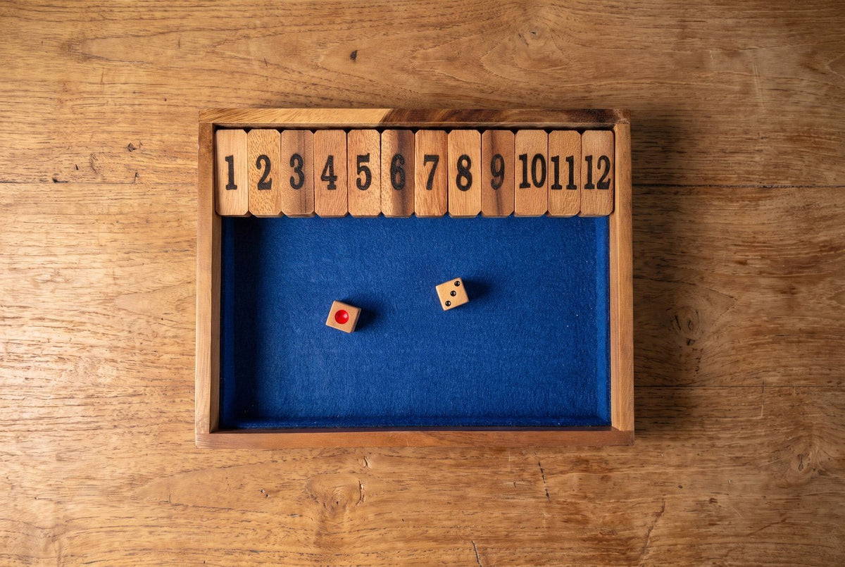 Wooden Shut the Box 1-12 board by Creative Crafthouse with blue lining and two dice, ready for a practice round.