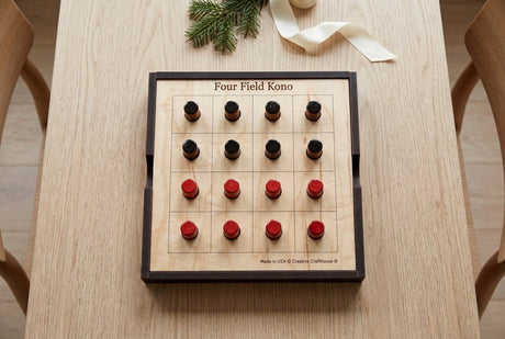 Creative Crafthouse Four Field Kono wooden board on a table, with eight black and eight red pegs in the starting grid