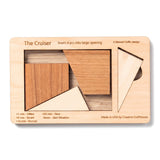 The Cruiser wooden packing puzzle by Creative Crafthouse, its four cut pieces set in the engraved board and side recess, on a white background
