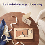 The Cruiser puzzle on a side table beside navy wrapping and a Happy Birthday Dad card, with the headline For the dad who says it looks easy.