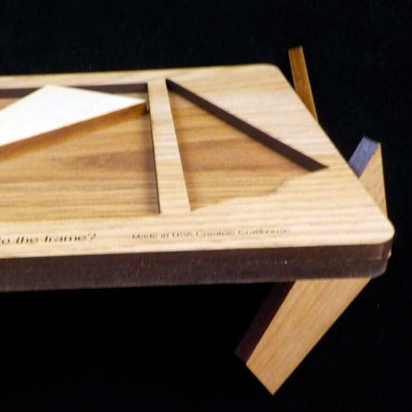 Angled close-up of a Cruiser frame edge engraved Made in USA Creative Crafthouse, with loose wooden puzzle pieces