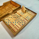 Double 6 wooden domino set with one tile standing upright to show its thickness and colored pips.