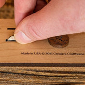 Dropping a penny into the Penny Drop game handmade by Creative Crafthouse