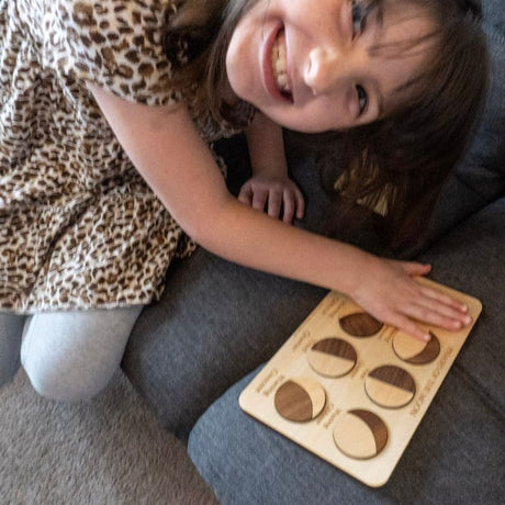 Child playing with the moon phases Montessori and STEM puzzle from Creative Crafthouse.