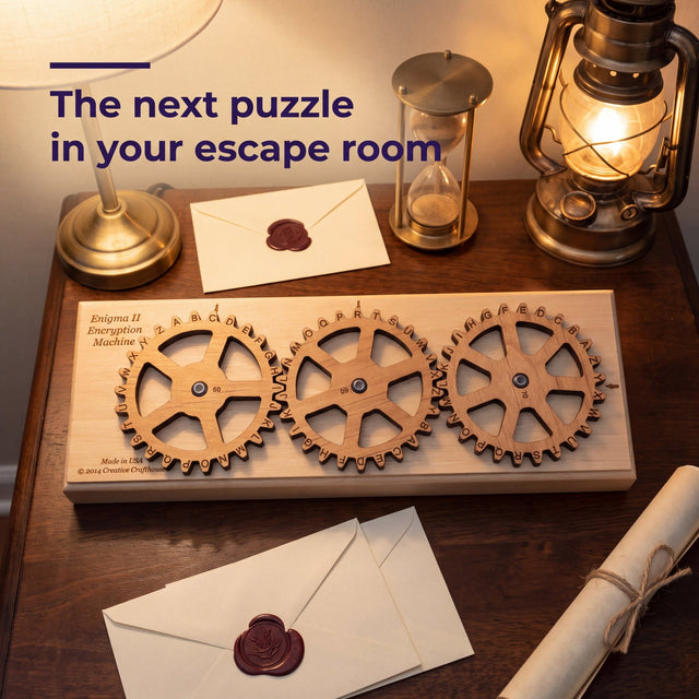 The Enigma II Small cipher machine on a desk with a lantern, an hourglass and wax sealed envelopes, headline The next puzzle in your escape room.
