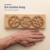 The Enigma II Small beside a flat hand for scale, labelled 9.4 inches long with 2.7 inch gears.