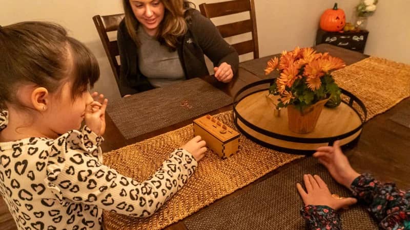 Family playing the Penny Drop Game from Creative Crafthouse.