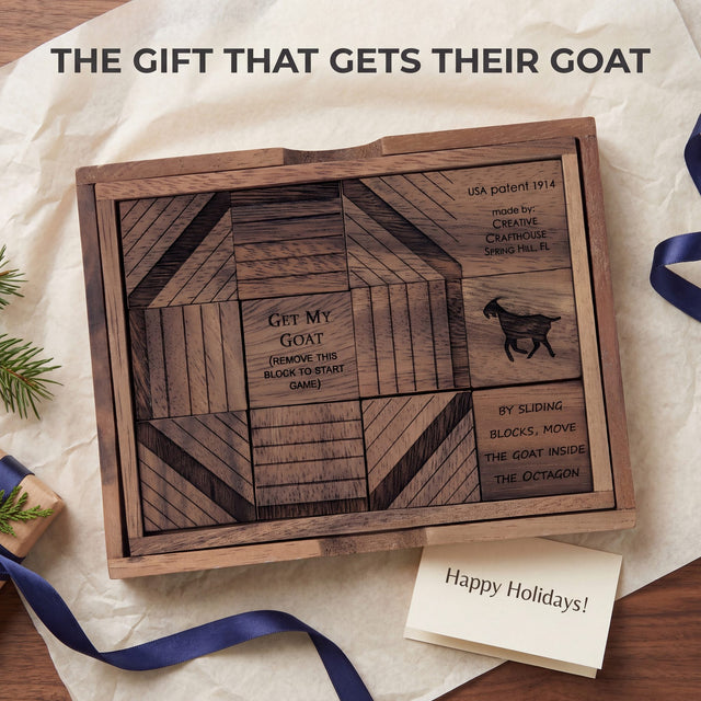 The Get My Goat wooden sliding block puzzle lying open on ivory tissue in a holiday gift scene, its engraved raintree blocks showing the octagon pattern, the goat silhouette and the USA patent 1914 maker line, with a kraft-wrapped present, indigo ribbon, evergreen sprigs and a Happy Holidays card. Headline: The gift that gets their goat.