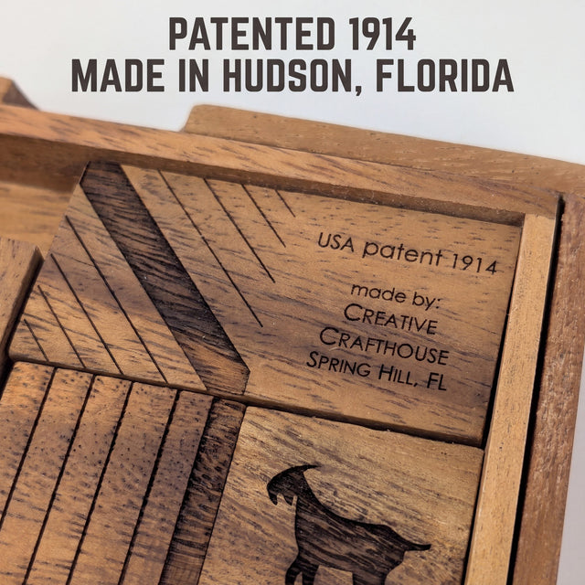 Close view of the maker engraving on the Get My Goat board, USA patent 1914, made by Creative Crafthouse, above the goat silhouette block. Headline: Patented 1914. Made in Hudson, Florida.