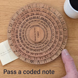 Mexican Army Cipher Wheel on an oak kitchen table with a folded note of number groups slid beside it