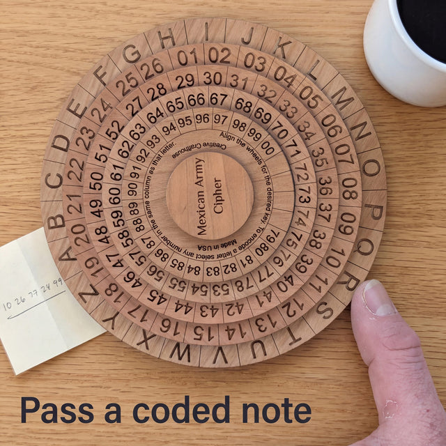 Mexican Army Cipher Wheel on an oak kitchen table with a folded note of number groups slid beside it