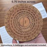 Mexican Army Cipher Wheel held in an adult hand, wider than the palm, with its instruction sheet and worksheet behind