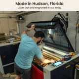 A Creative Crafthouse team member loading wood pieces into a laser cutter in the Hudson, Florida workshop