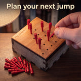 Late game on Peg Jump 6, seven red pegs left as a hand plans the next jump, removed pegs piled beside the box. Headline: Plan your next jump.