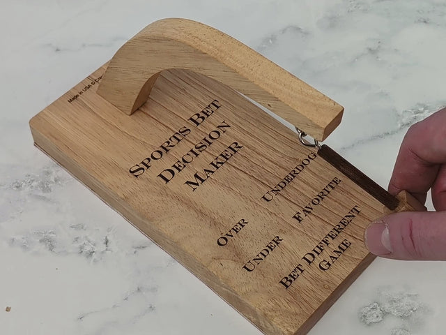 Video of the Sports Bet Decision Maker by Creative Crafthouse: one screw joins the arm to the base in under a minute, then a flick of the pendulum swings it until a magnet catches it on one of the five calls