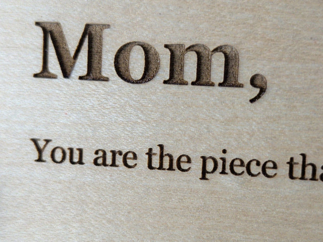 Close view of the laser engraved serif lettering on a Baltic birch Wood Message Card, with dark letters set into the fine wood grain